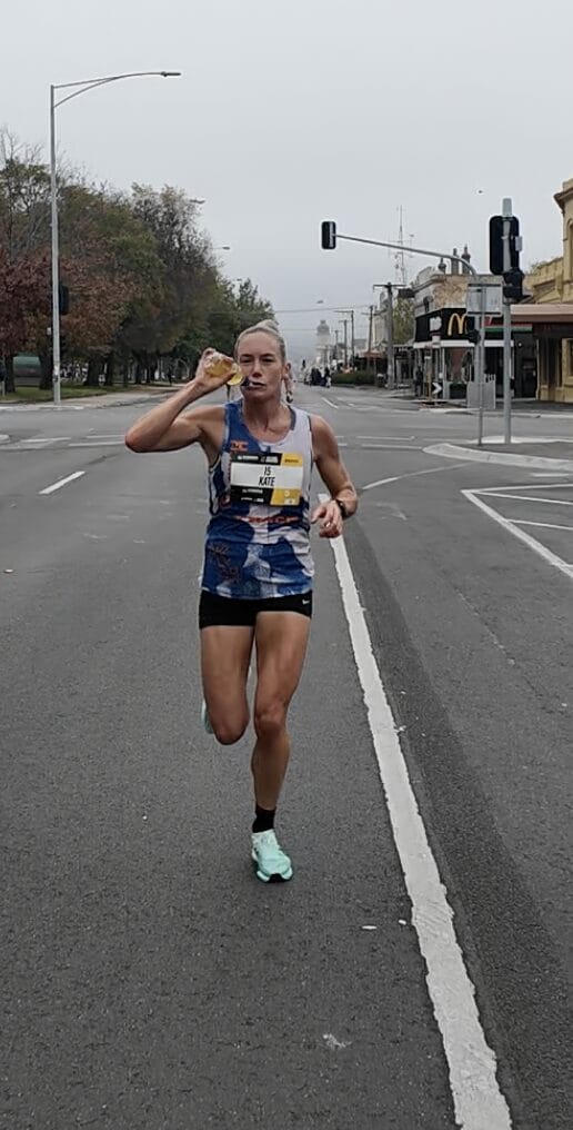 Kate, having some mid race hydration and fuel on her way to winning the Ballarat Marathon